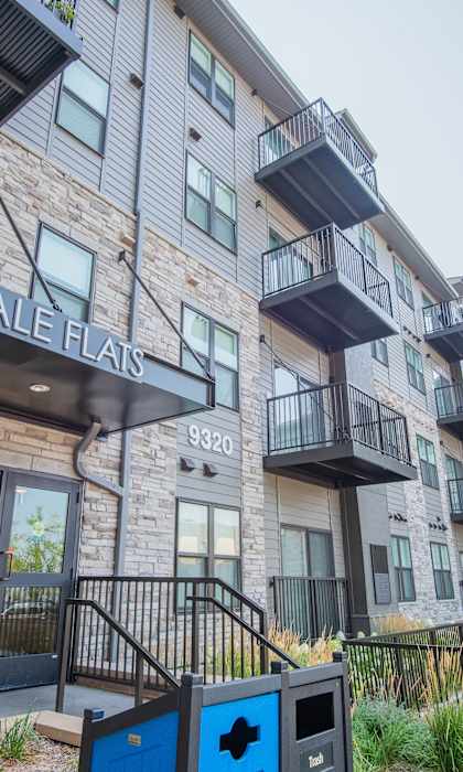 A modern apartment complex named Lyndale Flats with a playground in front.