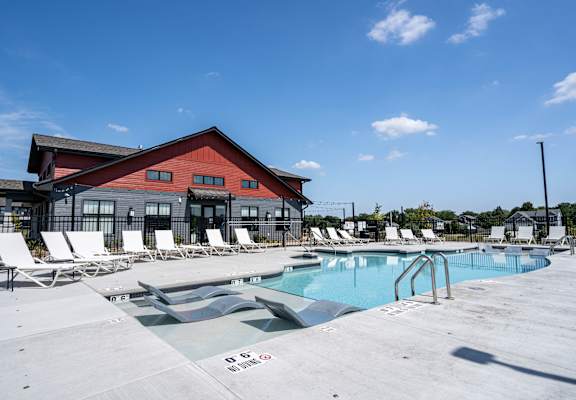 A pool with a red building behind it.