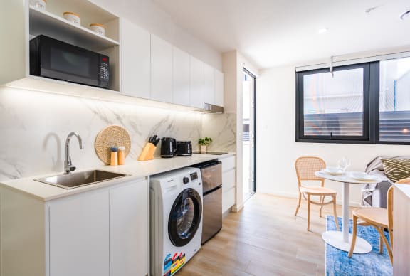 a kitchen with a washing machine and a sink and a window