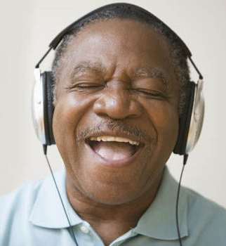 a man wearing headphones and smiling with his eyes closed