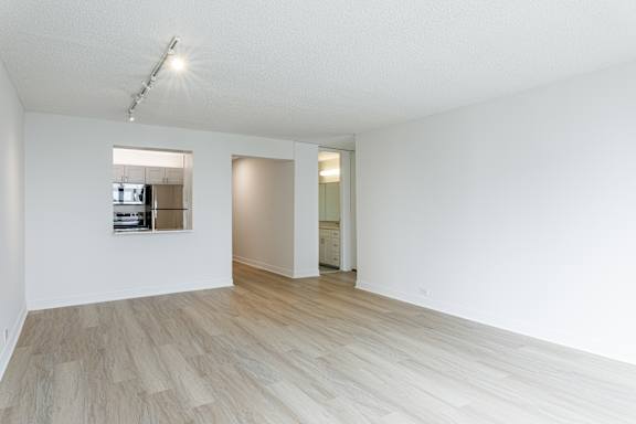 A room with wooden flooring and a mirror on the wall.