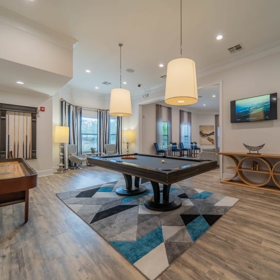 a game room with a pool table and a tv