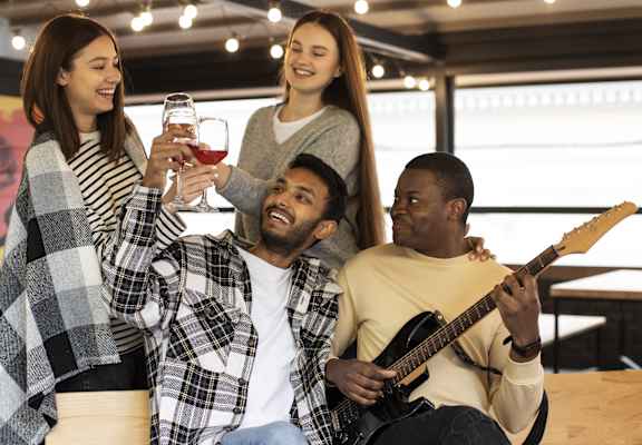 Three friends toasting with wine glasses in a casual setting.