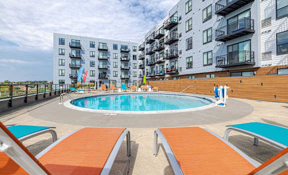 an apartment swimming pool in front of an apartment building