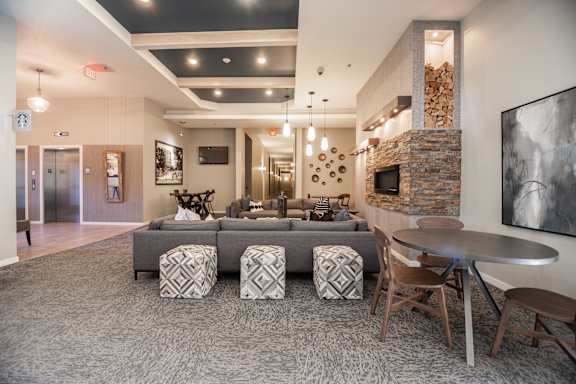 A modern living room with a stone fireplace and grey sofa.
