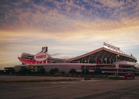A large stadium with a red sign on the top.