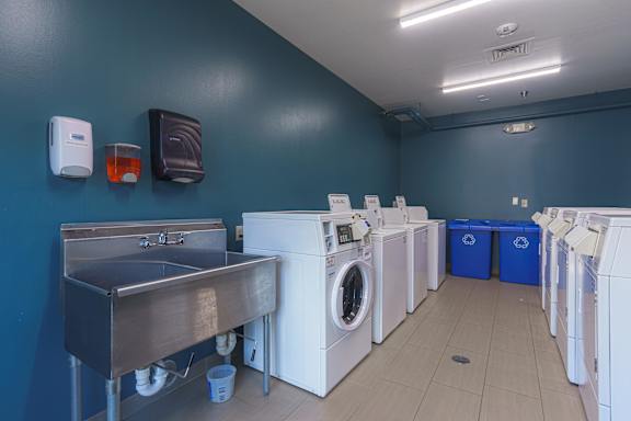 a laundry room with washes and washing machines and a sink at AVIA Lofts on Victors Way, Ann Arbor, MI