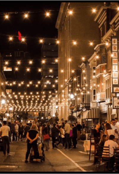 a crowd of people walking down a city street at night