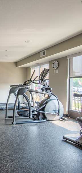 A gym with a variety of equipment including treadmills, weights, and exercise machines.