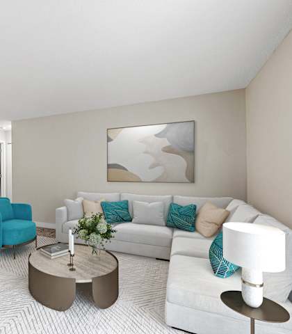 A living room with a white couch, blue chair, and a coffee table.