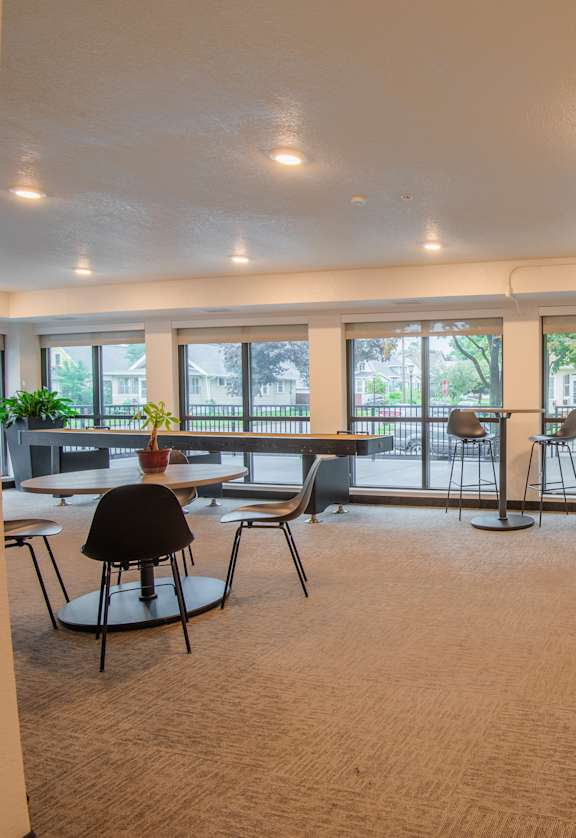 A room with a long couch and a table with chairs.
