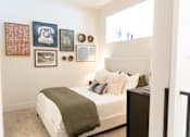 Thumbnail 6 of 9 - A bedroom with a bed, nightstand, and pictures on the wall. at District on the Etowah Apartments, Canton, GA 30114