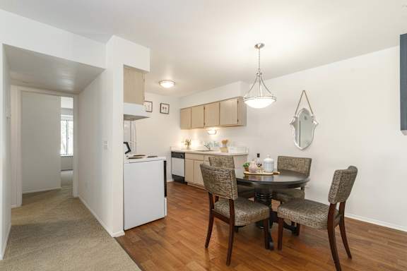 A dining room with a table and chairs.