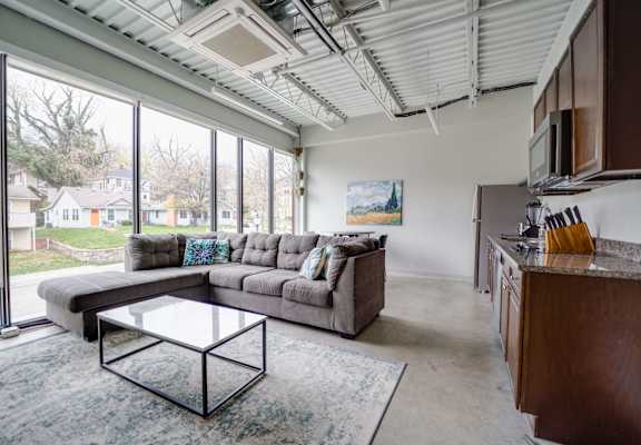 a living room with a couch and a coffee table in front of a large window