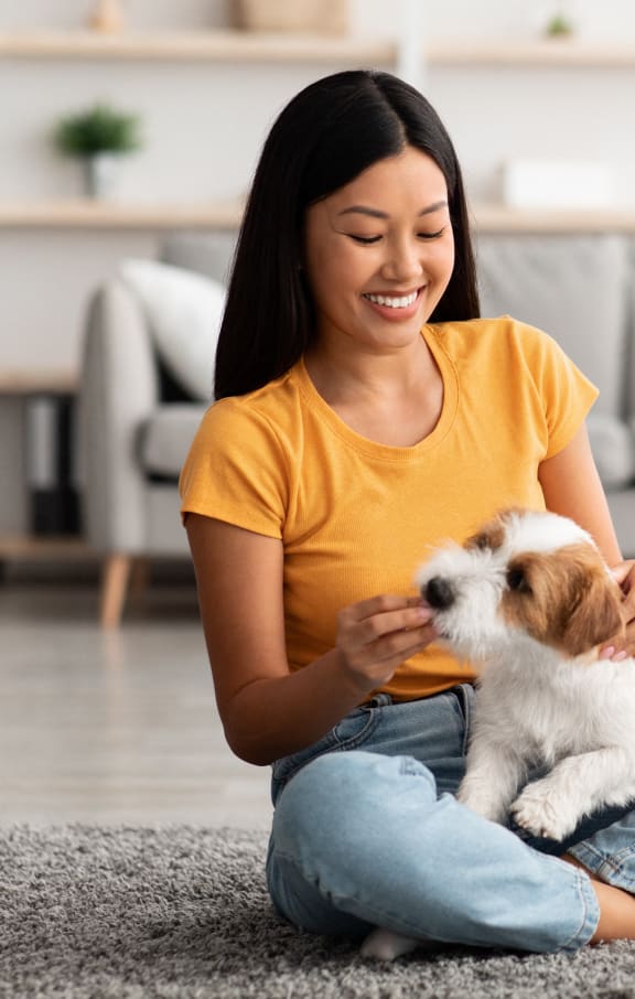 a woman sitting on the floor petting a small dog at GrandView Flats and Townhomes, Granger