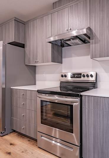 A modern kitchen with a stainless steel refrigerator and oven.