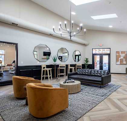 a lobby with couches and chairs and a bar with mirrors