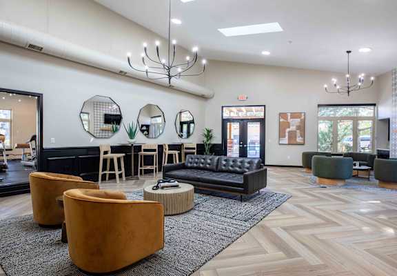 a lobby with couches and chairs and a bar with mirrors