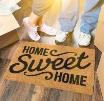 a couple standing on a home sweet home welcome mat