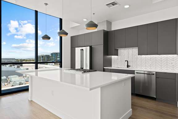 A modern kitchen with a large island and a view of the city.