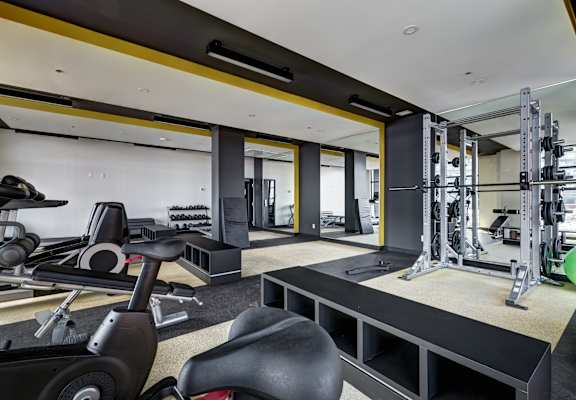 A gym with a variety of equipment including a treadmill, weights, and a bench press. at Plisko Place, Port Orchard, 98366