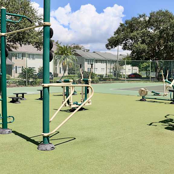 A playground with green equipment and a green fence.