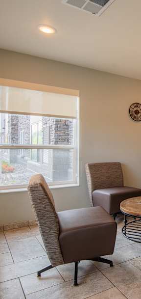 A room with a brown chair, a brown table, and a brown wall hanging.