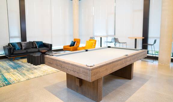 a pool table in a room with couches and chairs