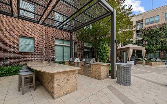 a patio with a hot tub and a grill