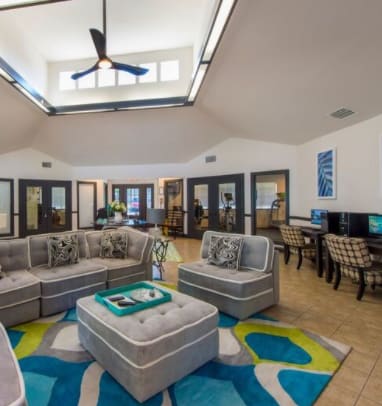a covered patio with couches and chairs and a tv