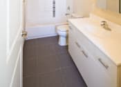 Thumbnail 7 of 11 - Bathroom with white cabinets and grey floor tiles