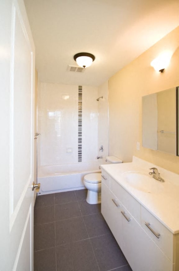 Bathroom with white cabinets and grey floor tiles