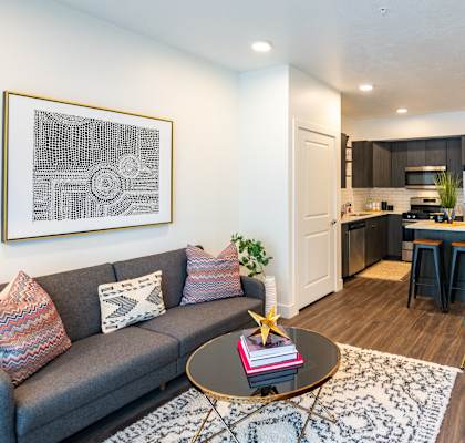 a living room and kitchen with a couch and a table