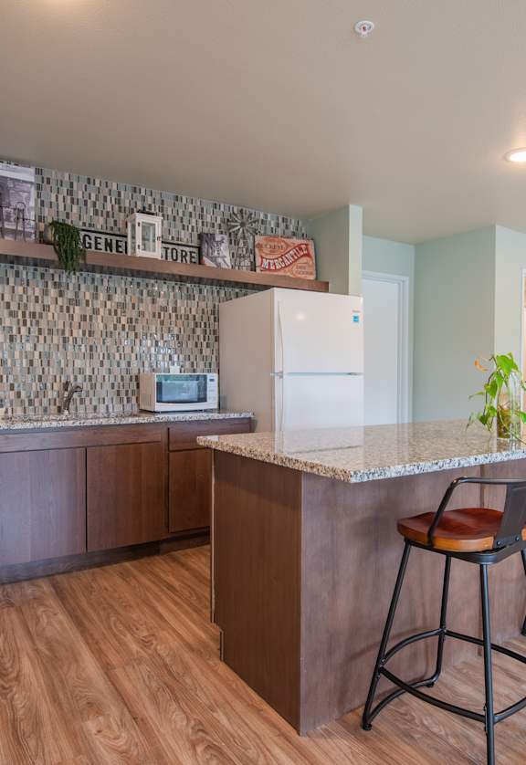 A kitchen with a bar and stools.