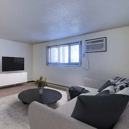 Grand Forks, ND Roughrider Apartments. a living room with white walls and a tv on the wall
