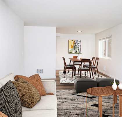 A living room with a white couch, a brown coffee table, and a painting on the wall.