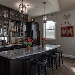 A kitchen with a large island and bar stools.