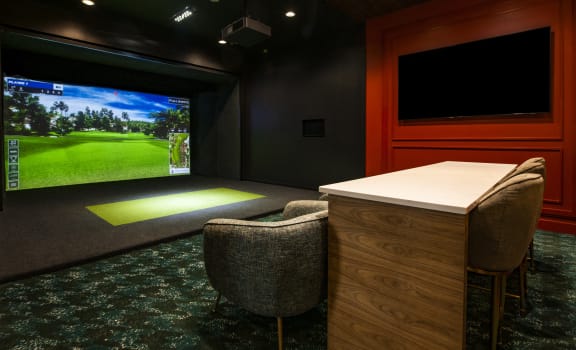 a home theater room with a bar and a large screen tv
