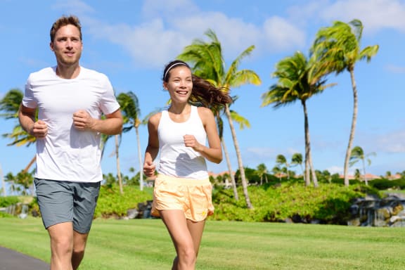 a man and a woman running in a park