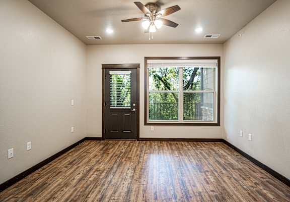 A room with a wooden floor and a ceiling fan.