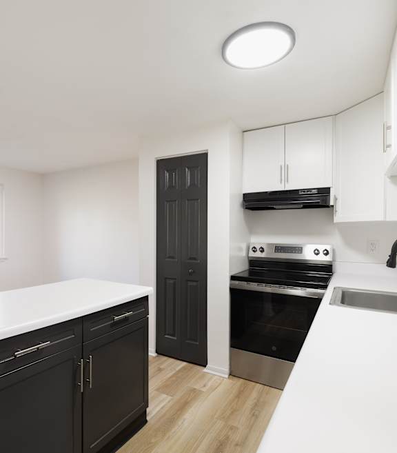 A modern kitchen with a refrigerator, oven, and sink.