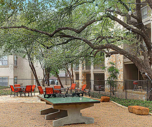 a picnic area with a ping pong table in front of an apartment building at Waters Edge Apartment Homes, Georgetown, 78626