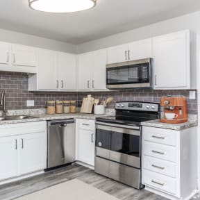 a kitchen with stainless steel appliances and white cabinets