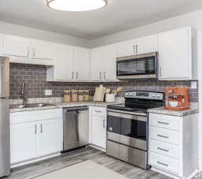 a kitchen with stainless steel appliances and white cabinets