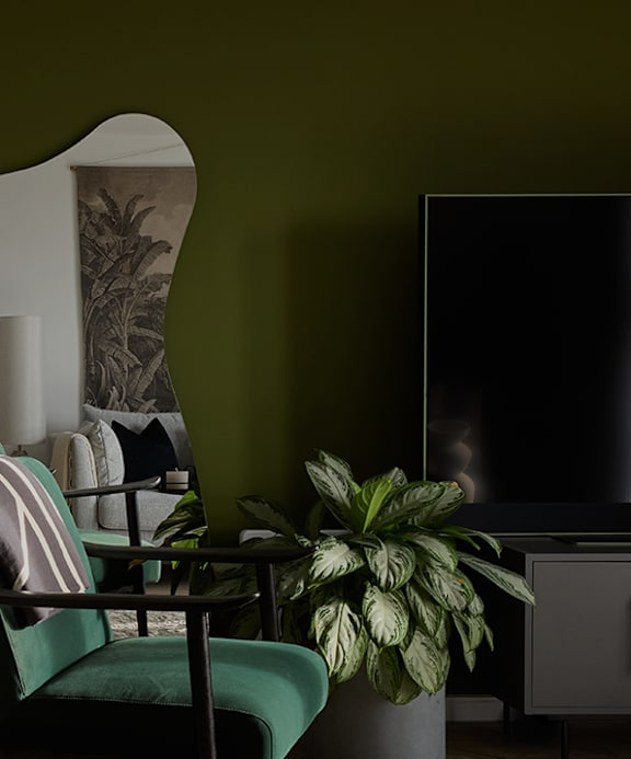 a living room with a couch with pillows and a plant