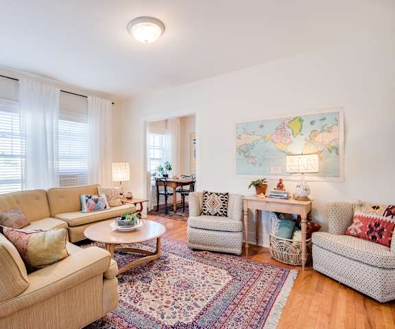 A living room with a couch, chairs, and a rug.