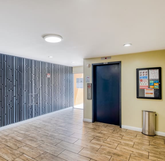 a hallway with a hallway wall with a door    and a trash can