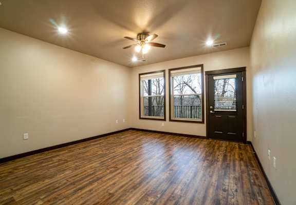 A room with wooden floors and a ceiling fan.