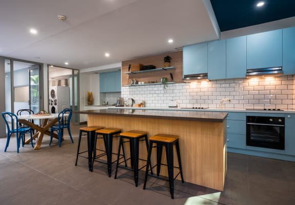 a kitchen with blue cabinets and a bar with stools