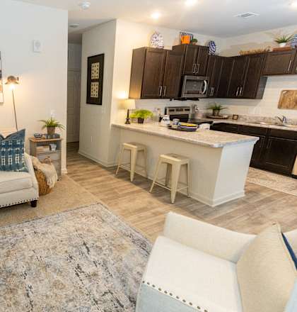 a living room with a couch and a kitchen